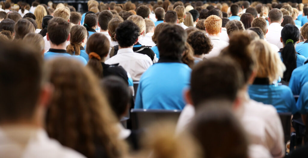 A group of people sitting in rows at an event.